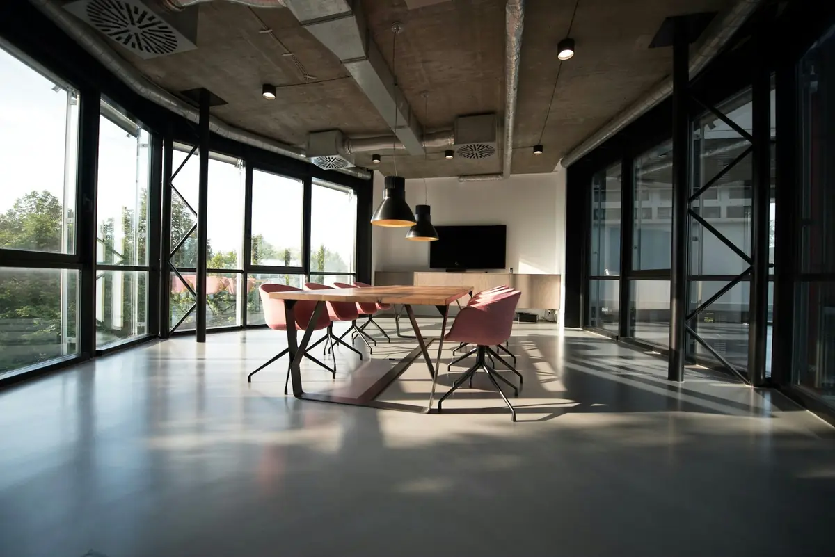 Beton tavanlı, geniş camlı açık ofis alanı
